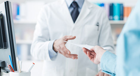 Male pharmacist issuing a prescription