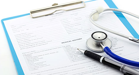 Stethoscope and pen on a form on a clipboard